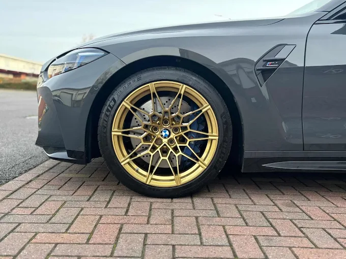 Gold multi-spoke alloy wheel on a grey BMW