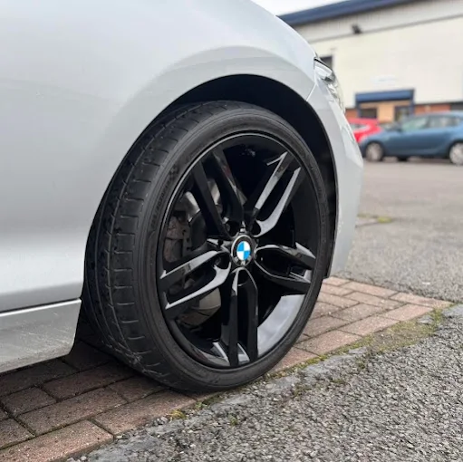 Gloss black BMW alloy wheel at the workshop