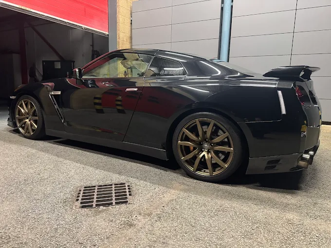 Custom gold alloy wheels fitted to a black Nissan GT-R