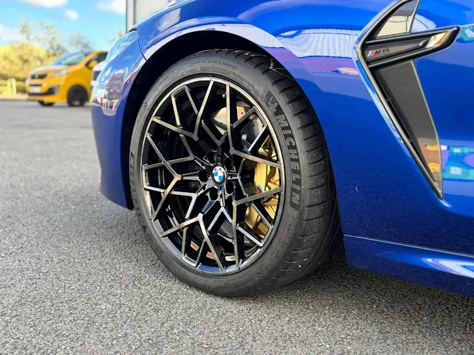 Freshly finished diamond-cut alloy wheel on a blue BMW at our Sheffield workshop